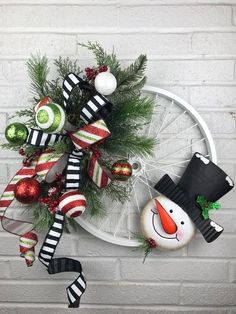 a christmas wreath hanging on the side of a brick wall next to a snowman ornament