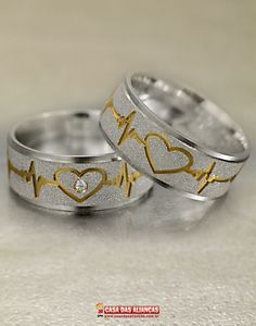 two wedding rings decorated with hearts and heartbeats