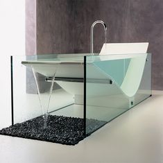 a modern sink and faucet in a bathroom with black pebbles on the floor