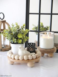 a potted plant sitting on top of a wooden stand next to a candle holder