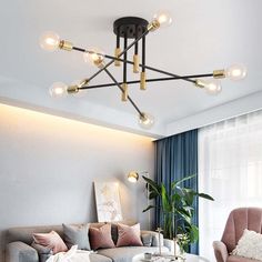 a living room filled with furniture and a chandelier hanging from the ceiling above it