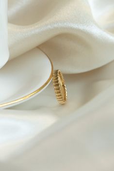 a gold ring sitting on top of a white plate