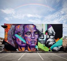 a large mural on the side of a building with two women's faces painted on it