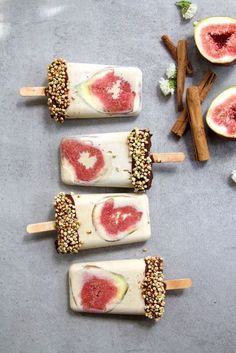 four popsicles with different toppings on them and some cinnamon sticks next to them