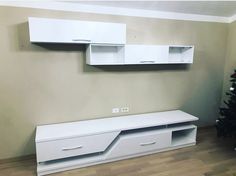 an empty room with two white cabinets and a christmas tree in the corner next to it