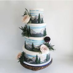 a three tiered cake decorated with flowers and greenery