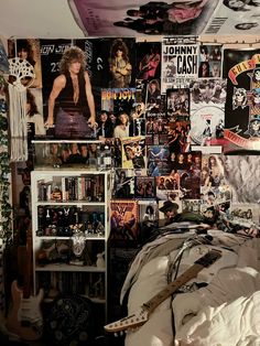 a bedroom with posters on the wall and a bed in front of it that has an electric guitar