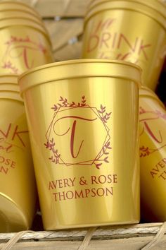 several gold cups with the names avery and rose thompson on them sitting in a wicker basket