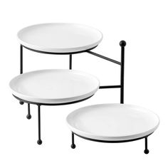 two white plates sitting on top of black metal stand with one plate in the middle