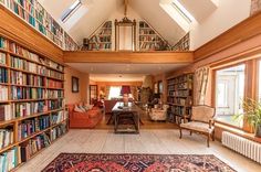 a living room filled with lots of furniture and bookshelves covered in bookcases