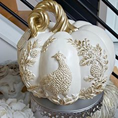 white pumpkins with gold trim sitting on top of a table