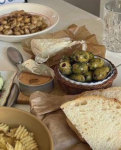 a table topped with plates of food next to bowls of salads and crackers