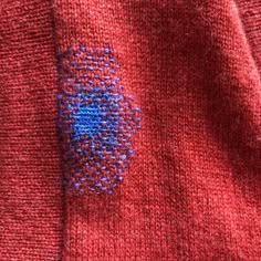 a red sweater with blue stitching on it