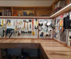 a workbench filled with lots of tools and wrenches hanging on the wall