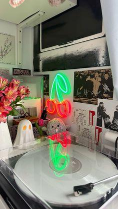 a turntable with neon lights on it and flowers in vases next to it