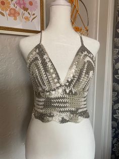 a white mannequin with a silver top on it