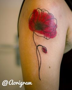 a woman's arm with a red flower tattoo on the left side of her shoulder