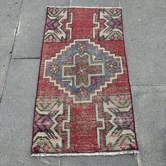 a red and blue rug on the sidewalk