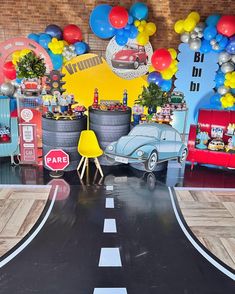 a car is parked on the road in front of balloons and other decorations for a birthday party