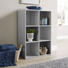 a living room with a chair, table and bookshelf on the carpeted floor