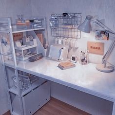 a white desk topped with lots of clutter next to a lamp and other items