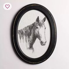 a black and white photo of a horse in a round frame on the wall next to a heart