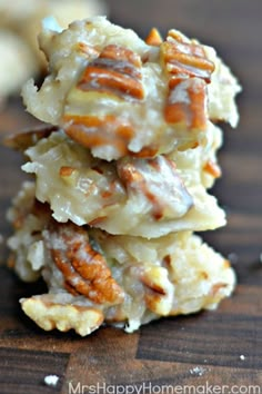 a stack of pecan cookies sitting on top of a wooden table next to another pile of pecans