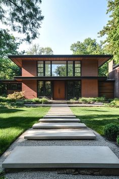 a modern house with stone steps leading up to the front door and grass area around it