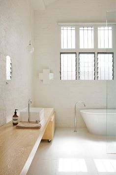 a bathroom with a tub, sink and window