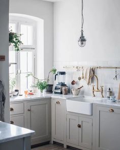 a kitchen filled with lots of white cabinets and counter top space next to a window