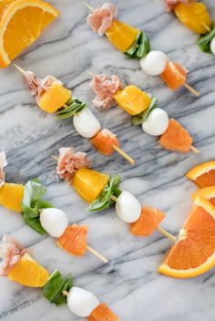 oranges and other fruits are arranged on skewers