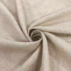 a close up view of the fabric on top of a white cloth with a small hole in it