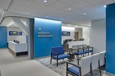 an empty waiting room with blue chairs and a sign on the wall that says radiology reception