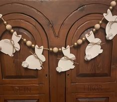 two wooden doors decorated with paper doves and twine string lights hanging from them