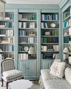 a living room filled with lots of furniture and bookshelves covered in blue bookcases