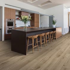 a kitchen with wooden flooring and counter top space next to an open living room