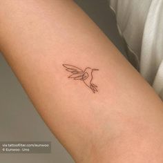 a small hummingbird tattoo on the arm