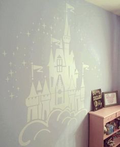 a child's room with a castle painted on the wall and bookshelf