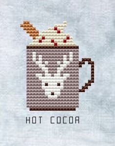 a cross stitch mug with hot cocoa in it