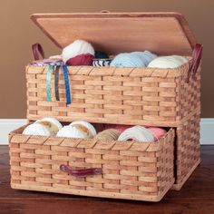 two wicker baskets filled with yarn on top of a wooden floor