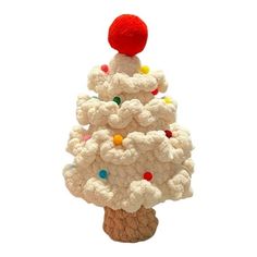 a white crocheted christmas tree with a red ball on it's top