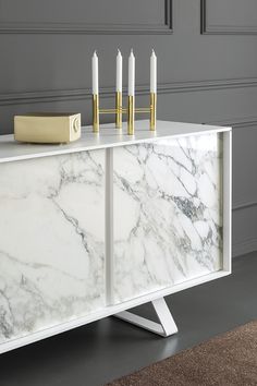 a white marble cabinet with candles on top