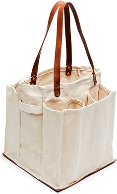 a white bag with brown handles and two pockets