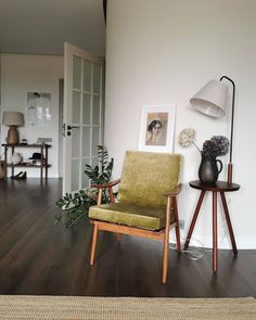 a living room filled with furniture and a painting on the wall next to a chair