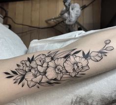 a black and white flower tattoo on the arm