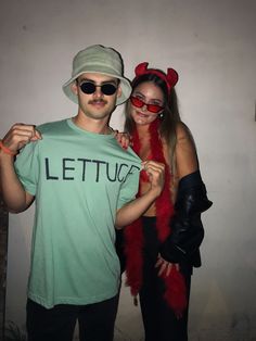 a man and woman dressed up as devil and demon with their arms around each other