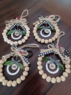 four christmas wreaths hanging on a wooden table