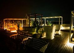 some chairs and tables on a deck at night