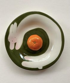 a bowl with an orange in the center