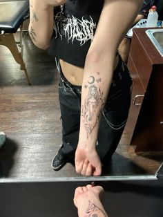 a person with tattoos on their arm and foot